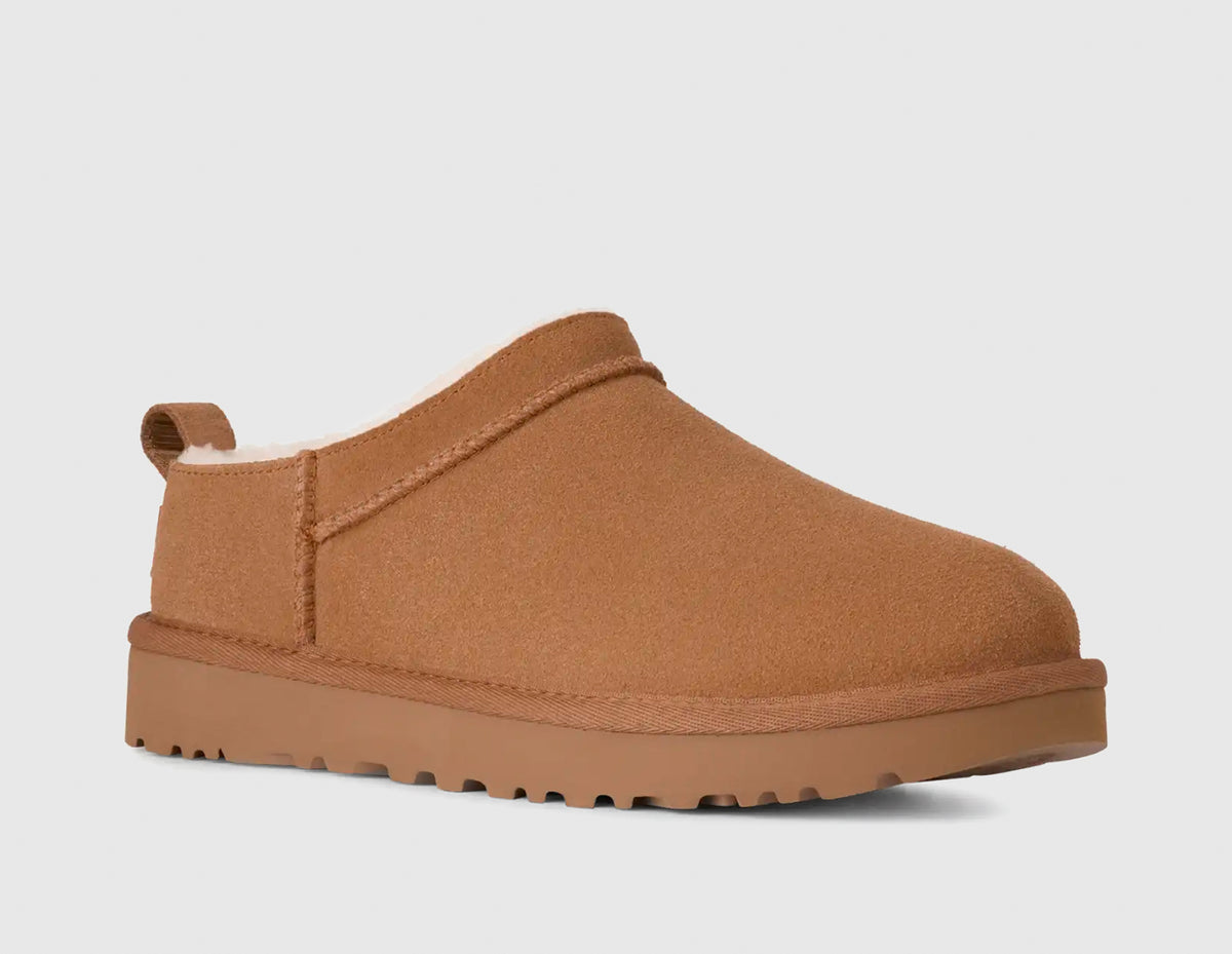 UGG Women's Classic Micro. Three-quarter view of single chestnut suede mini boot showing low-profile silhouette, overlock stitching, and tonal EVA sole. 