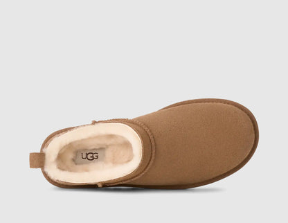 UGG Women's Classic Micro. Top view of single chestnut suede mini boot showing plush cream sheepskin lining, footbed logo branding, and low-cut collar. 