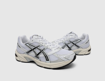 ASICS GEL-1130. Three-quarter view of pair of white running shoes showing white mesh upper, black overlays, and white laces. 