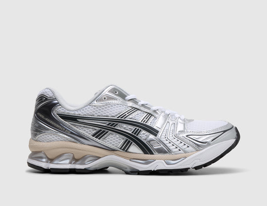ASICS GEL-KAYANO 14. Side view of white mesh running shoes featuring graphite grey and silver overlays, beige midsole accent line, and visible GEL cushioning units. 