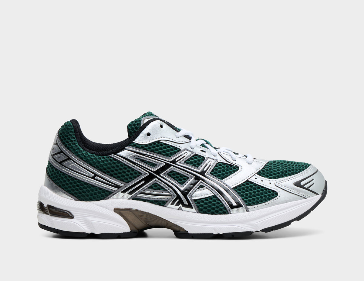 ASICS GEL-1130. Side view of running shoes featuring an evergreen mesh base upper with metallic silver synthetic overlays, black-outlined ASICS tiger stripes, white EVA foam midsole with GEL technology cushioning, and dark TRUSSTIC midfoot support system. 