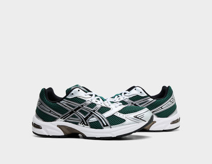 ASICS GEL-1130. Three-quarter view of pair of running shoes showing deep evergreen mesh uppers, metallic silver synthetic overlays, white laces, and cushioned midsoles. 