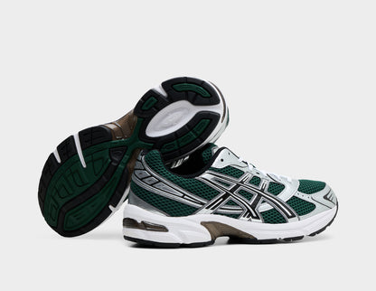 ASICS GEL-1130. Dynamic view of pair of running shoes with one shoe turned on its side to show the dark green and black rubber outsole with midfoot TRUSSTIC shank system. 