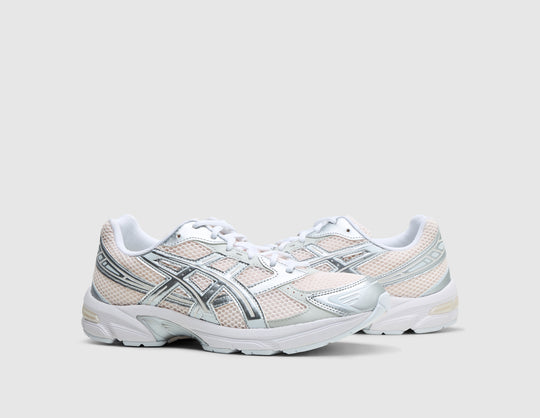 ASICS GEL-1130. Three-quarter view of pair of running shoes showing blush pink mesh uppers, metallic pure silver overlays, white laces, and off-white midsoles. 