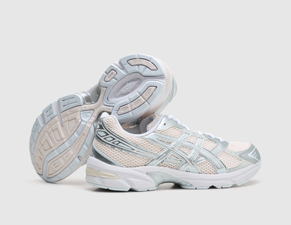 ASICS GEL-1130. Dynamic view of pair of running shoes with one shoe resting on its side to display the light grey and blush rubber outsole with visible midfoot TRUSSTIC shank. 