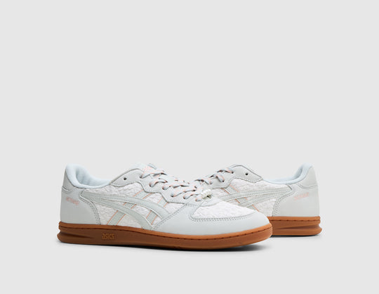 ASICS SKYHAND OG. Three-quarter view of pair of glacier grey leather sneakers showing textured woven quarter panels, speckled laces, glacier grey side stripes, and gum rubber soles. 