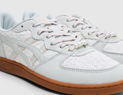 ASICS SKYHAND OG. Close-up three-quarter view of glacier grey leather upper showing textured woven toe box and quarter panels, speckled laces, exposed foam tongue edge, and pearl lace dubrae. 