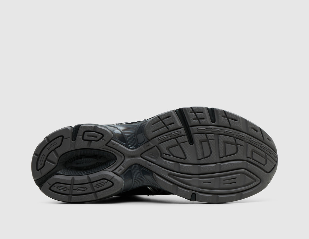 ASICS GEL-1130 Mule. Bottom view of single black backless mule showing rubber traction outsole pattern with central TRUSSTIC support unit. 