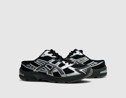 ASICS GEL-1130 Mule. Three-quarter view of pair of black backless mules showing metallic graphite grey overlays, and black laces. 