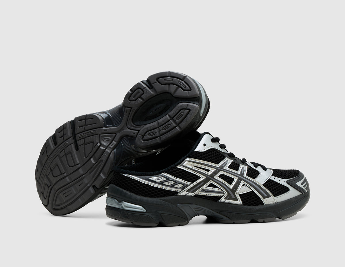ASICS GEL-1130 Mule. Side view of stacked black backless mules showing dark rubber outsole traction pattern and GEL heel cushioning. 