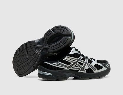 ASICS GEL-1130 Mule. Side view of stacked black backless mules showing dark rubber outsole traction pattern and GEL heel cushioning. 