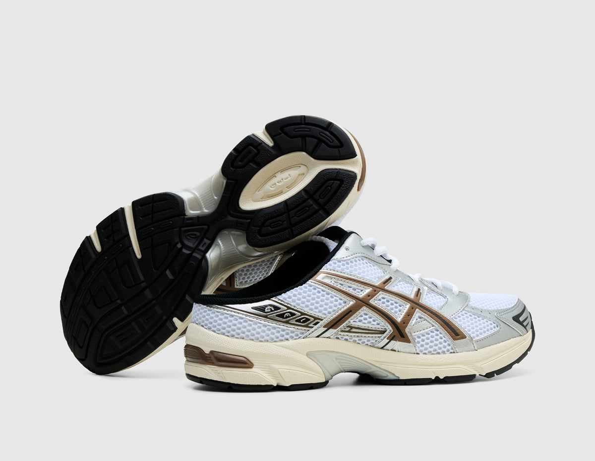 ASICS GEL-1130 Mule. Side view of stacked white open-back mule sneakers showing dark rubber outsole traction pattern and GEL heel cushioning.
