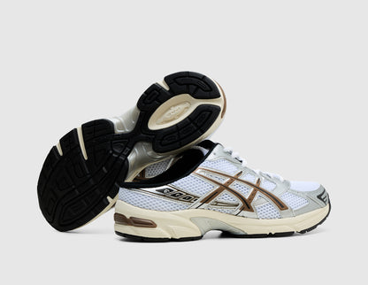 ASICS GEL-1130 Mule. Side view of stacked white open-back mule sneakers showing dark rubber outsole traction pattern and GEL heel cushioning.