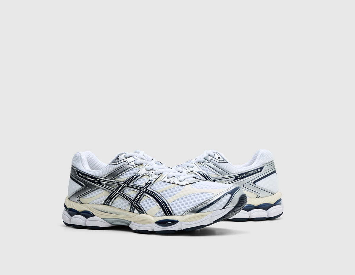 ASICS GEL-CUMULUS 16. Three-quarter view of pair of white running shoes showing metallic silver and midnight overlays, white laces, and cushioned midsole. 
