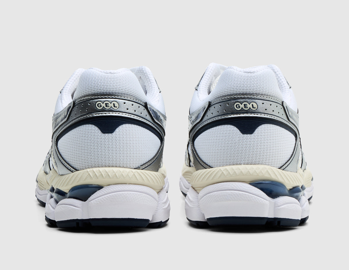 ASICS GEL-CUMULUS 16. Rear view of pair of white running shoes showing metallic silver heel counters, GEL logo branding, and midnight outsole units. 