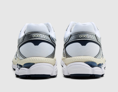 ASICS GEL-CUMULUS 16. Rear view of pair of white running shoes showing metallic silver heel counters, GEL logo branding, and midnight outsole units. 