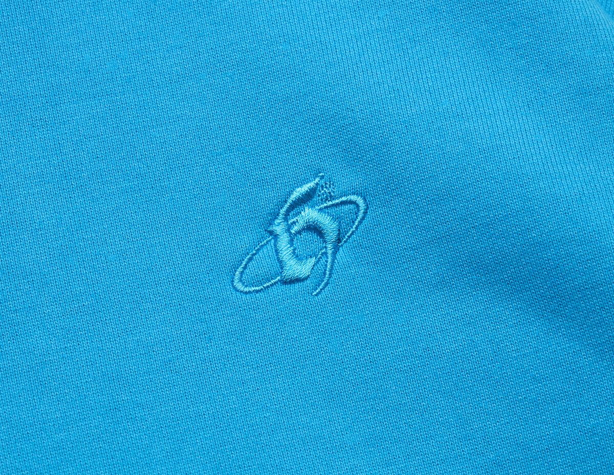 Home Grown Brutal HD Hoodie. Close-up of malibu blue fleece showing tonal embroidered “h” logo on the chest. 
