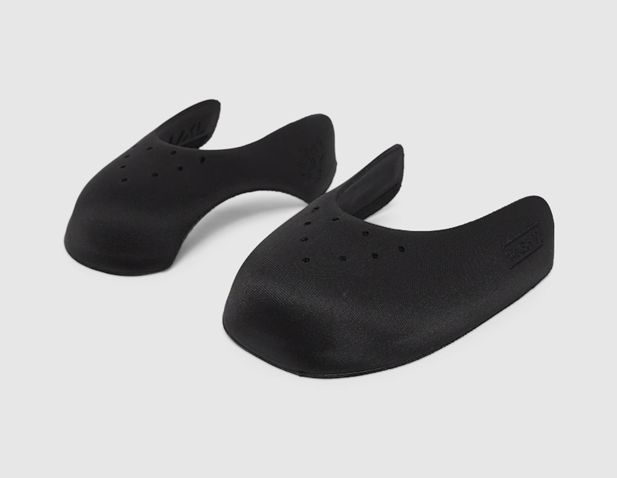 Pair Crep Protect Sneaker Guards 3.0. Front view of a pair of black anti-crease shoe guards with ventilation holes. 