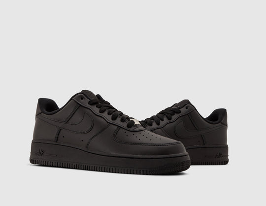 Nike Air Force 1 '07. Three-quarter view of pair of black leather sneakers showing silver lace dubrae and black laces. 