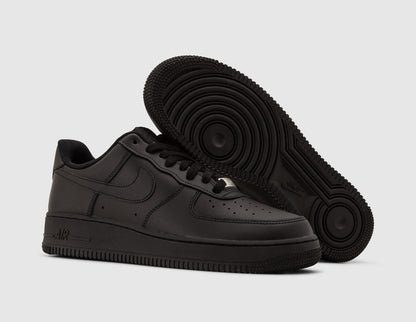 Nike Air Force 1 '07. Three-quarter view of black leather sneakers showing dark rubber traction outsole pattern and silver lace dubrae. 