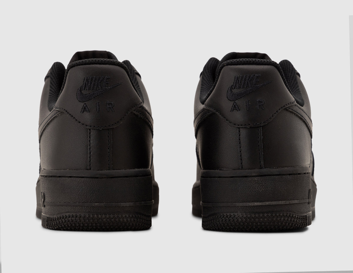 Nike Air Force 1 '07. Rear view of pair of black leather sneakers showing embroidered Nike Air heel branding and black cupsole. 