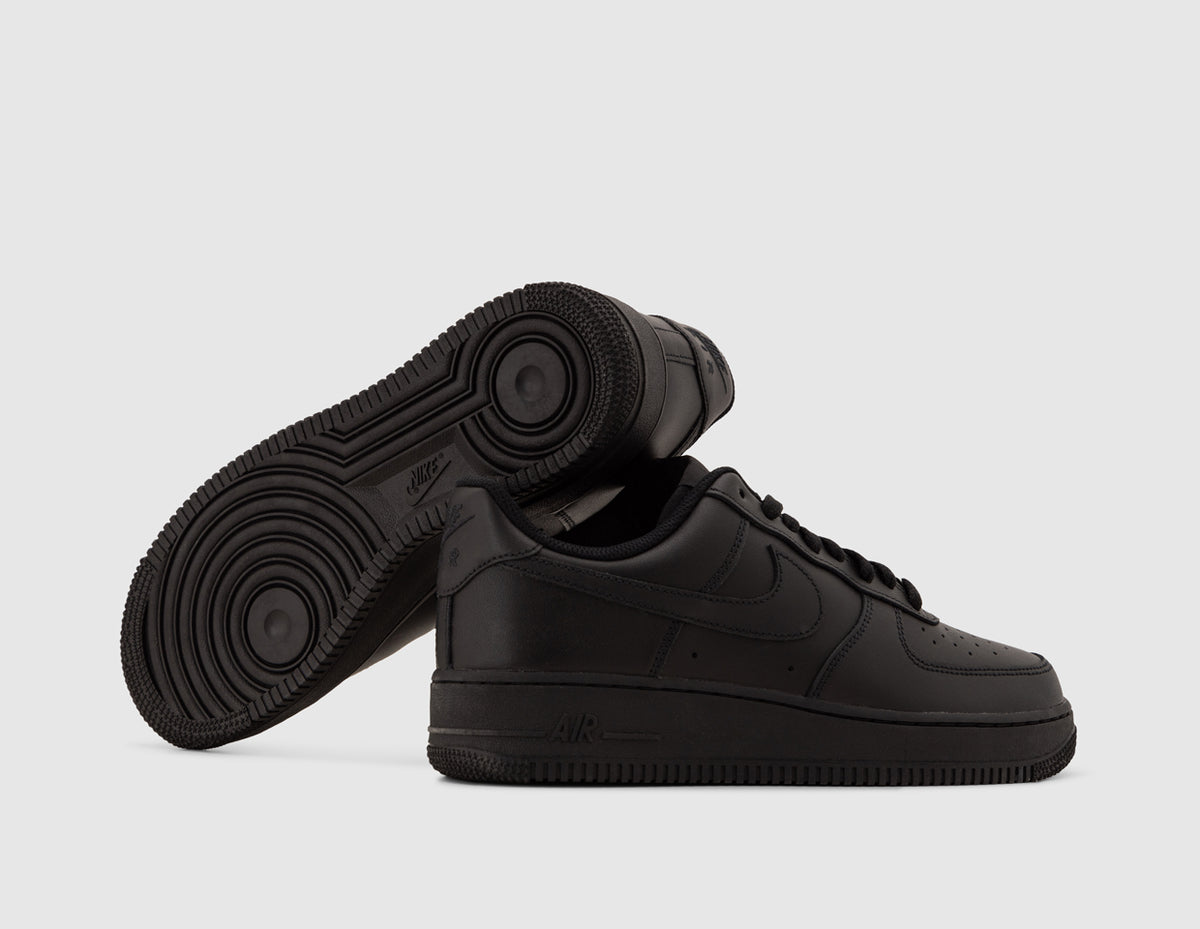 Nike Air Force 1 '07. Side view of stacked black leather sneakers showing rubber outsole pivot points and AIR midsole. 