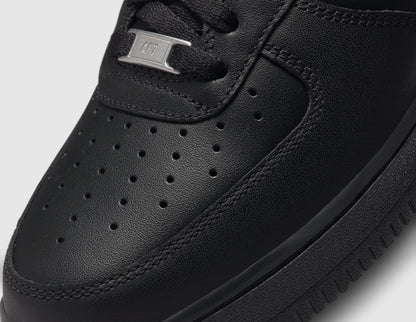 Nike Air Force 1 '07. Close-up of black leather toe box showing perforated ventilation holes and silver metal AF1 lace dubrae. 