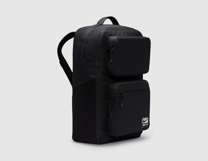 Nike Utility Speed Backpack (27L). Three-quarter view of black training backpack showcasing side profile, dual front zippered utility compartments, and side pocket construction. 