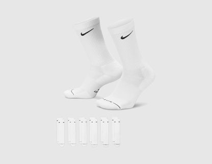 Nike Everyday Elevated Crew Socks (6-Pack). Side view of a pair of white crew socks standing upright above six flat white socks. 