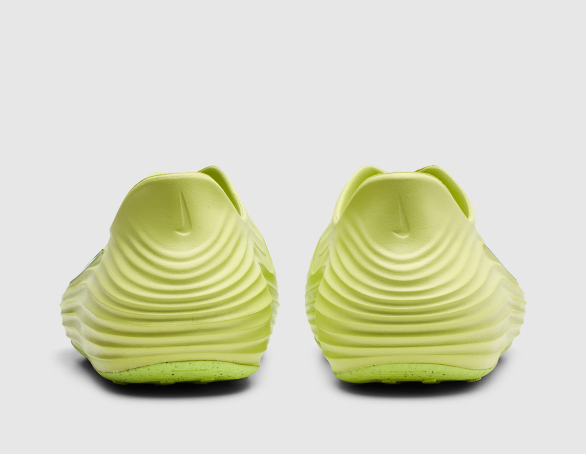 Nike Women's ReactX Rejuven8. Rear view of pair of light lemon twist foam mule slip-on shoes showing wave-textured sculpted heel counters and exaggerated padded collar lip. 