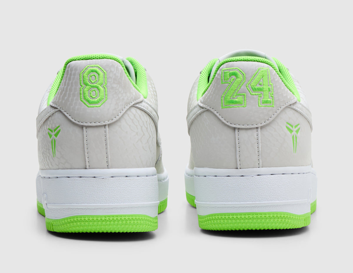 Nike Kobe Air Force 1 Low. Rear view of pair of vast grey sneakers showing electric green embroidered numbers "8" and "24" on back heel tabs, Kobe Sheath logos on lateral heels, and white Air midsoles. 