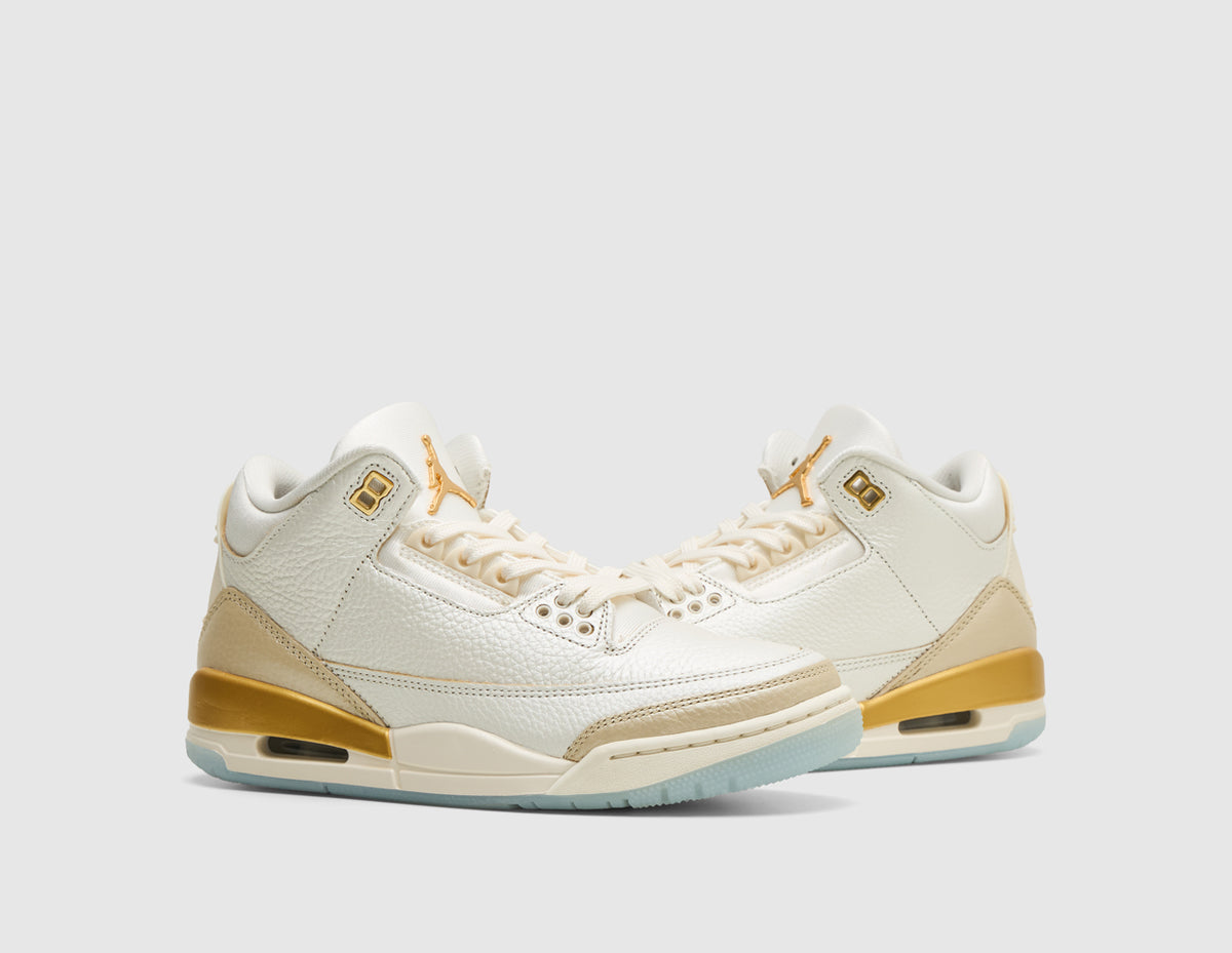 Jordan Women's 3 Retro. Three-quarter view of pair of sail tumbled leather basketball shoes showing team gold eyelets, pale ivory laces, and metallic gold midsole detailing. 