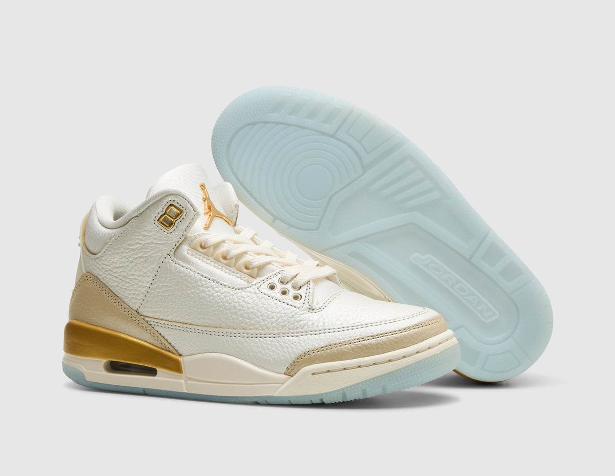 Jordan Women's 3 Retro. Three-quarter view of sail tumbled leather basketball shoes with one shoe propped to display the icy light blue rubber outsole. 