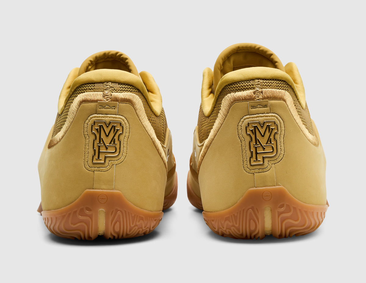 Nike LeBron XXIII "Honor Society". Rear view of wheat gold basketball shoes showing MVP graphic heel emblems and gum outsoles. 