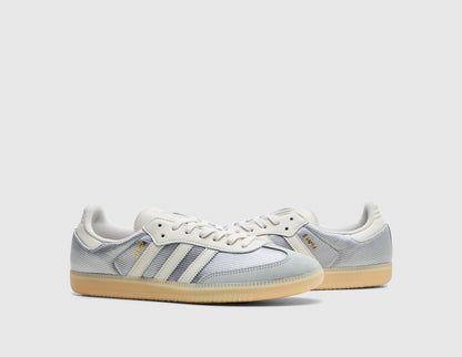 adidas Originals Samba OG. Three-quarter view of pair of grey two sneakers showing chalk white laces and gold Samba branding. 