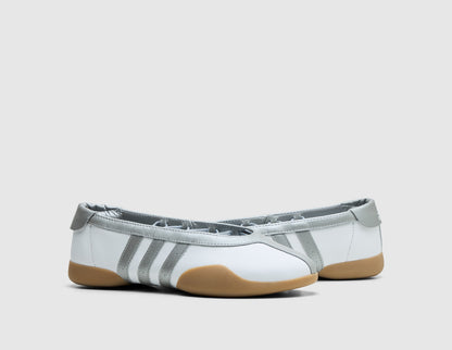 adidas Originals Women's Taekwondo Mei Ballet. Three-quarter view of white leather slip-on shoes showing silver metallic elastic collar and three-stripes. 