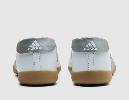 adidas Originals Women's Taekwondo Mei Ballet. Rear view of white leather slip-on shoes showing metallic silver heel overlays with white adidas Trefoil logos. 