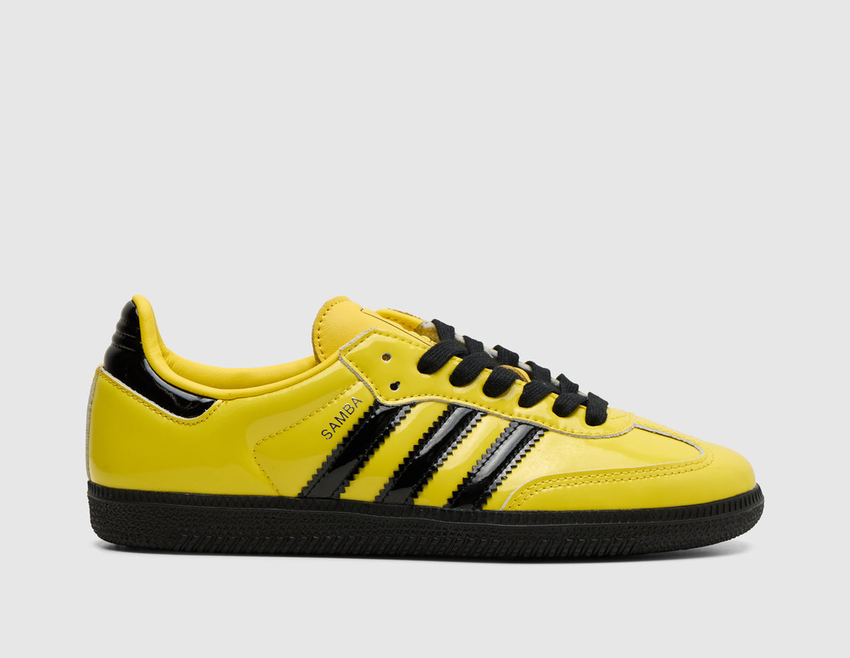 adidas Originals Samba OG. Side view of yellow patent leather sneakers featuring core black three-stripes, yellow T-toe overlay, and low-profile black sole. 
