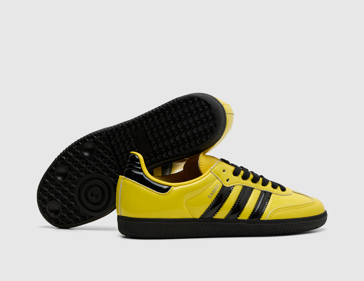 adidas Originals Samba OG. Side view of stacked yellow leather sneakers showing core black three-stripes and black rubber outsole. 