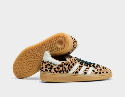 adidas Women's Handball Spezial. Side view of stacked leopard print sneakers showing white three-stripes and gum sole traction pattern. 