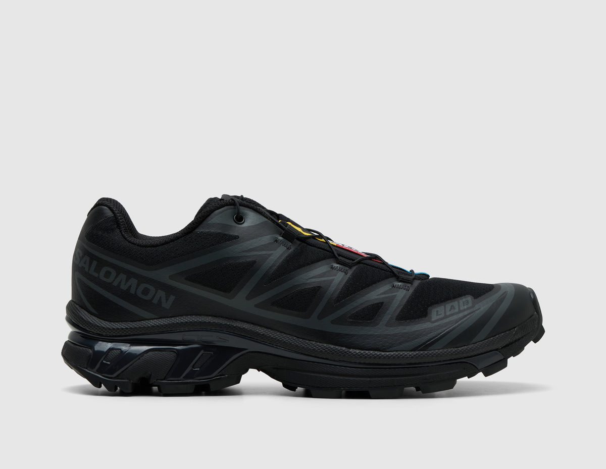 Salomon XT-6. Side view of triple black trail running shoes featuring phantom synthetic overlays, black Salomon branding, and lugged sole. 