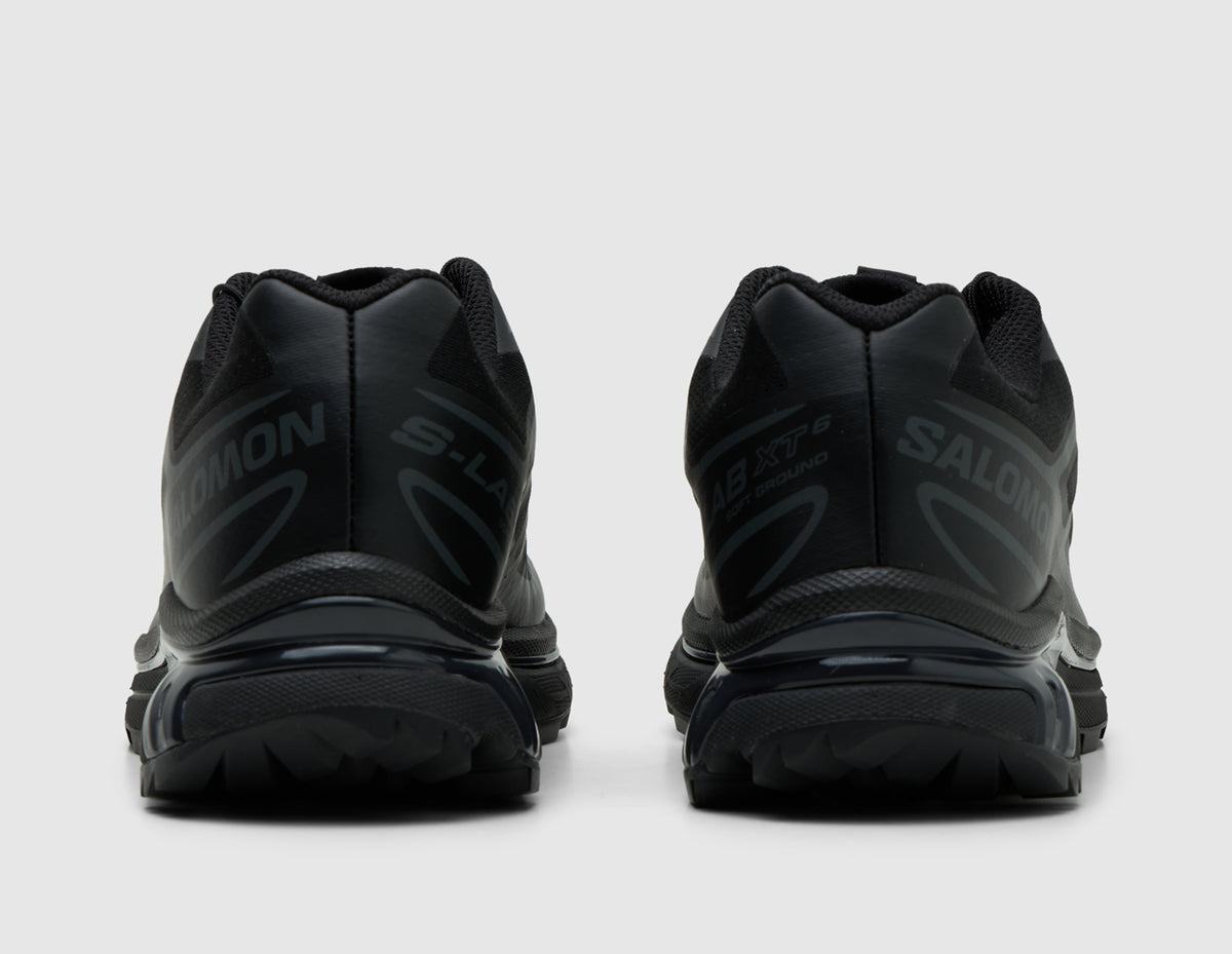 Salomon XT-6. Rear view of pair of triple black trail running shoes showing black heel counters and Agile Chassis System heel support. 