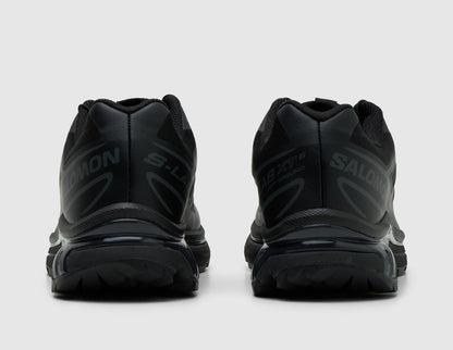 Salomon XT-6. Rear view of pair of triple black trail running shoes showing black heel counters and Agile Chassis System heel support. 
