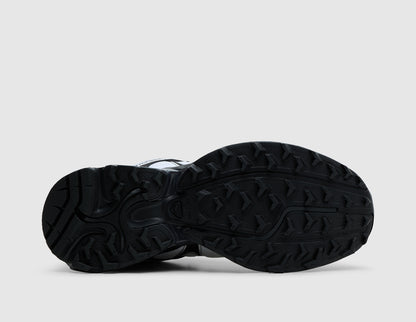 Salomon XT-Whisper. Bottom view of single black and white trail running shoe showing black Contagrip rubber lugged traction outsole pattern. 
