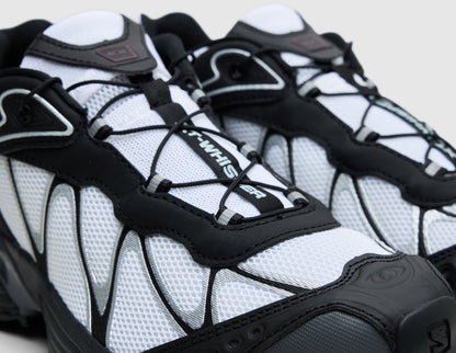 Salomon XT-Whisper. Close-up three-quarter view of white upper showing black webbed overlay cage, Quicklace lacing system, and black toe cap reinforcement. 