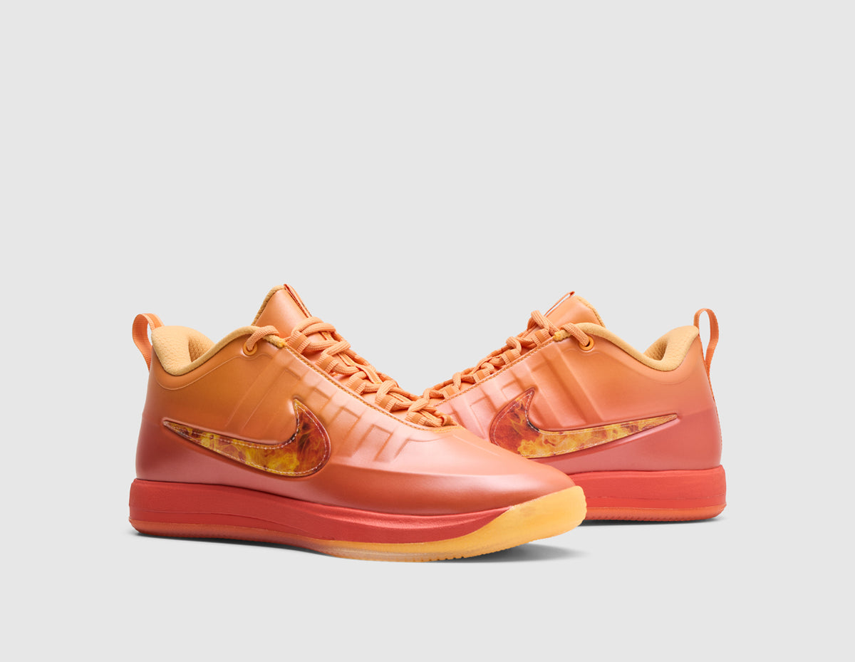 Nike Book 2 "The Phoenix". Three-quarter view of pair of sundial orange basketball shoes showing gradient upper finish, flame-graphic Swoosh, matching sundial laces, and orange rubber outsole trim. 