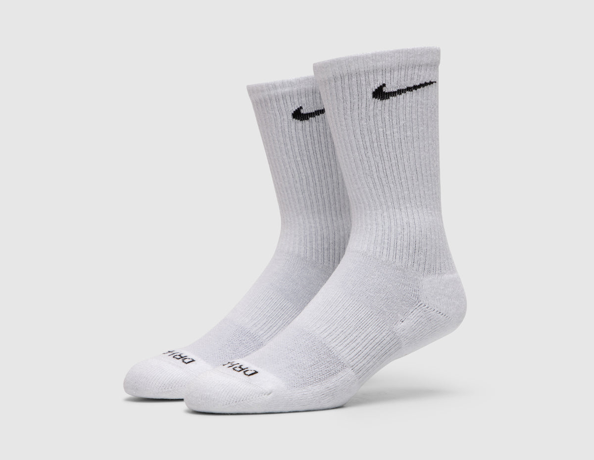 Nike Everyday Plus Cushioned Socks (3-Pack). Side profile view of white crew socks showing ribbed ankle cuffs and reinforced heel and toe. 