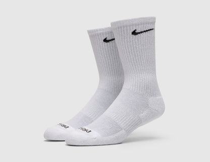 Nike Everyday Plus Cushioned Socks (3-Pack). Side profile view of white crew socks showing ribbed ankle cuffs and reinforced heel and toe. 