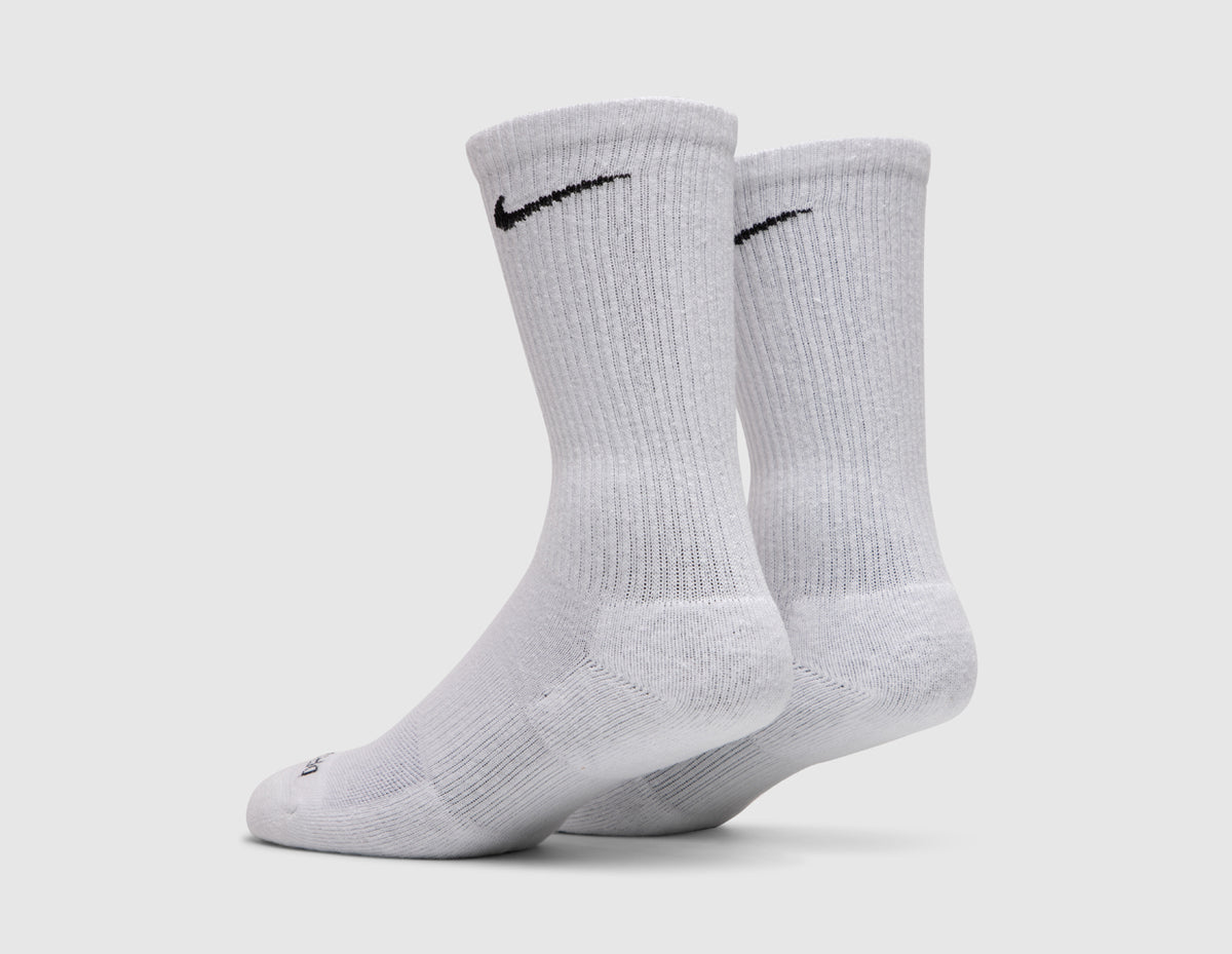 Nike Everyday Plus Cushioned Socks (3-Pack). Back three-quarter view of pair of white crew socks showing black Swoosh logos and ribbed cuffs. 