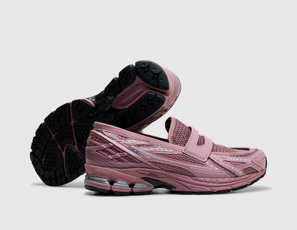 New Balance 1906L. Three-quarter view of rosewood pink loafers with one shoe turned to showcase the black rubber traction outsole. 